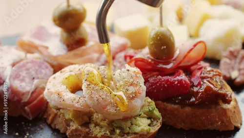 Italian or Spanish restaurant with traditional tapas food, Spanish cuisine, delicious tapas and cheese plate, bruschetta with cheese, olives dry tomatoes and tasty sandwich bar appetizer, buffet
