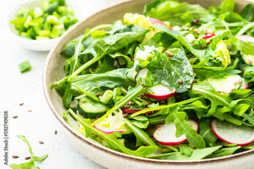 Spring salad with spinach  arugula  radish with olive oil and seeds.