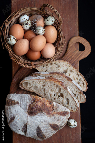 Sliced handmade bread and a basket of chicken and quail eggs.