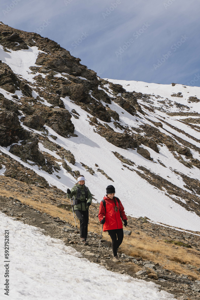 Two friends hiking in the mountains at winter