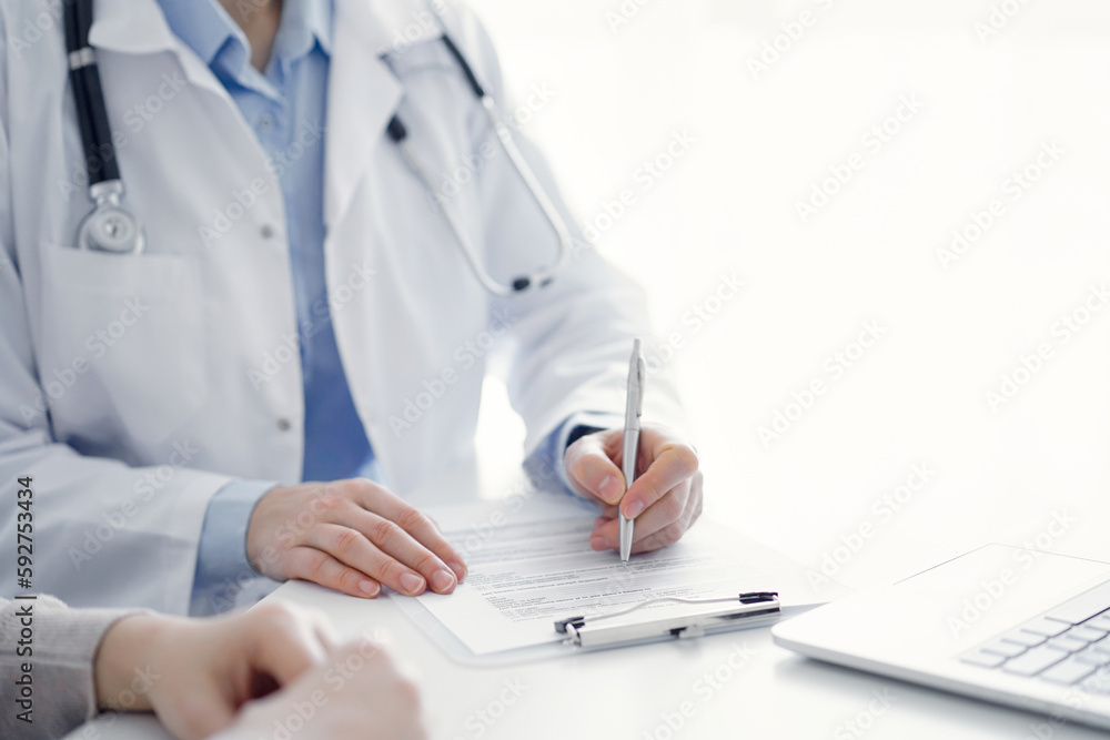 Doctor and patient discussing current health questions while sitting at the table in clinic office, only hands closeup. Medicine concept Doctor and patient discussing current health questions while sitting at the table in clinic office, only hands closeup. Medicine concept