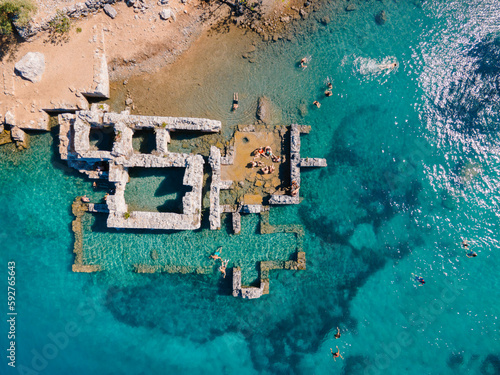 Aerial drone photo of swimmers enjoying the beautiful Kleopatra Hamamı Cove, located between Göcek and Dalaman, Turkey, known for its crystal-clear waters and ancient ruins. © gokcen