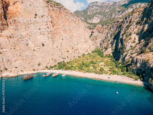 Aerial drone photo capturing the pristine Butterfly Valley in Ölüdeniz, Fethiye, Muğla. This valley is a popular point for tour boats.