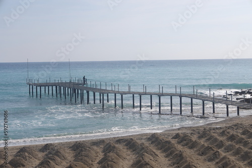 Heaps of sand for the beach against the backdrop of the pier and the sea  Alanya  Turkey  April 2023.