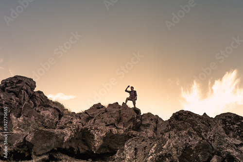 Hiker getting ready to climb up mountain looking up at the challenge before him. Believe in yourself, overcoming challenges, pushing forward concept. 