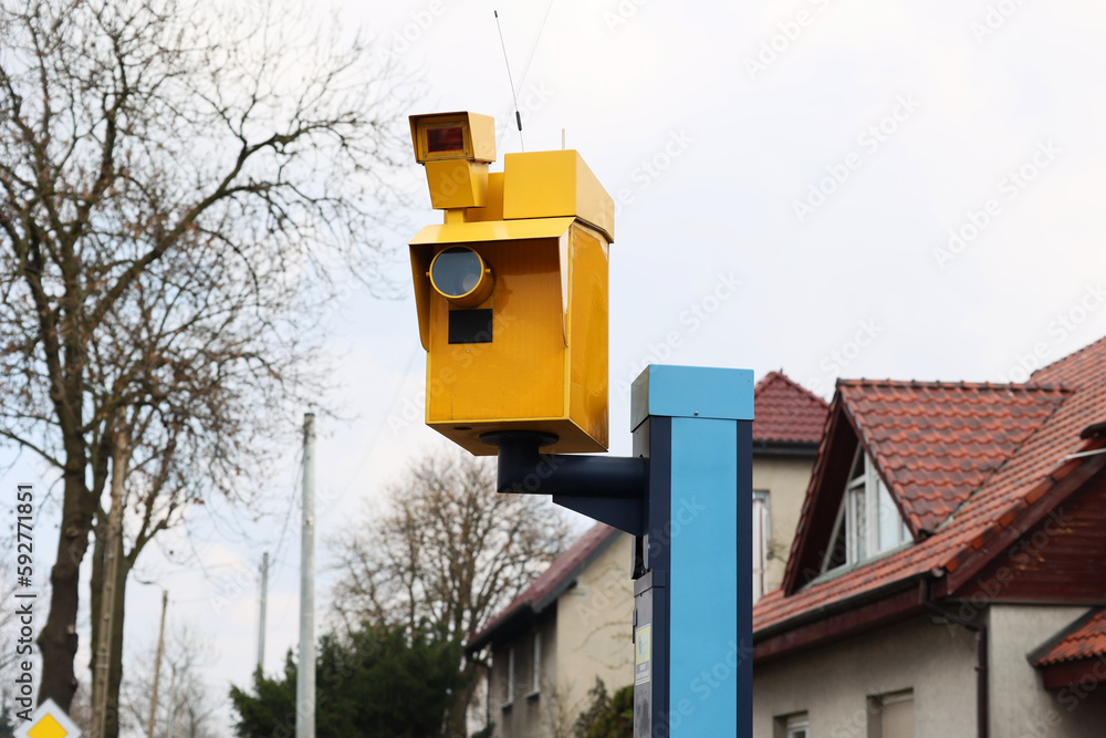 Żółty fotoradar robi zdjęcia wykroczeń drogowych kierowcom samochodów.  - obrazy, fototapety, plakaty 