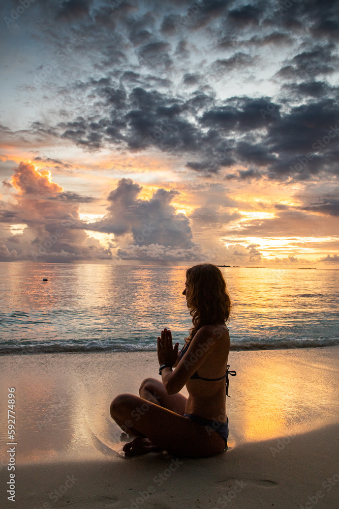 woman doing yoga on exotic beach