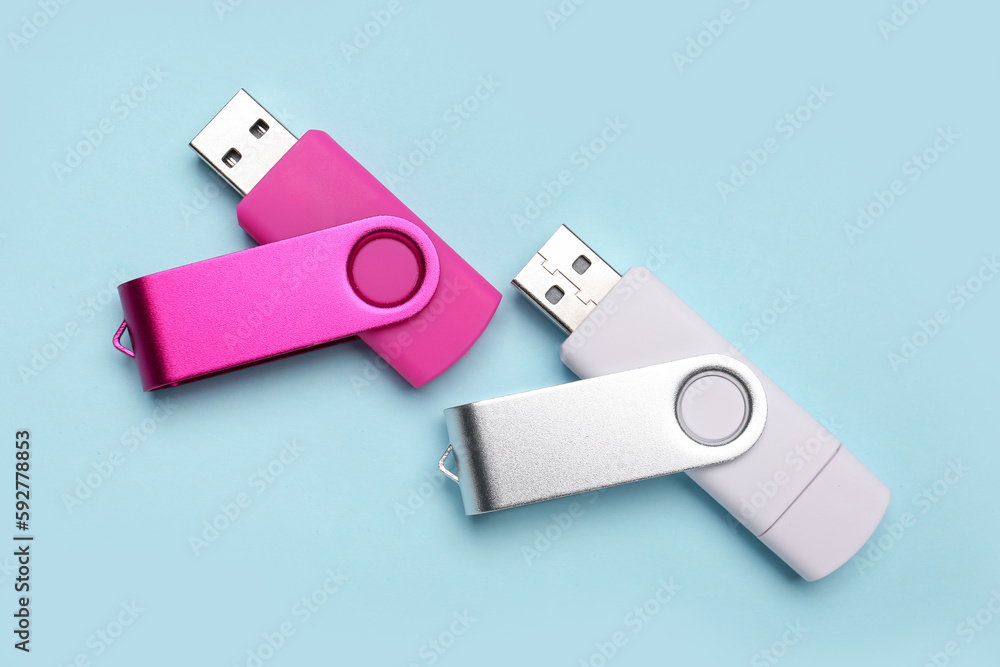 Pink and white USB flash drives on blue background Pink and white USB flash drives on blue background