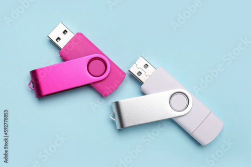 Pink and white USB flash drives on blue background