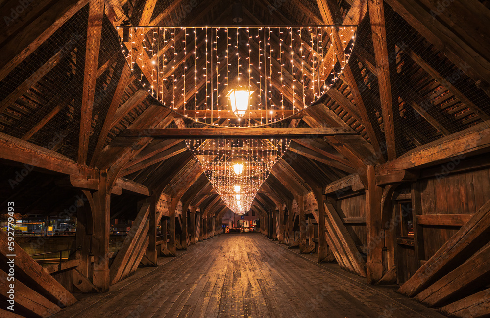 Illuminated by festive lighting, a stunning wooden bridge guides the way forward in Olten, Switzerland.