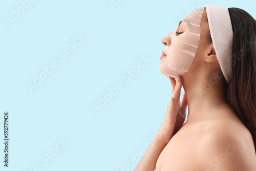 Young woman with sheet mask...