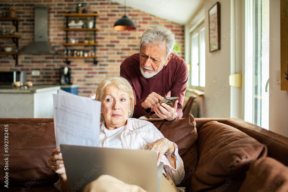 Obraz premium Senior couple going over their bills in a living room
