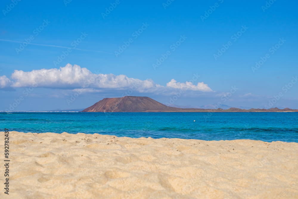 View on Corralejo beach and Lobos island, blue water and golden sand and the Canary Island Fuerteventura, Spain.