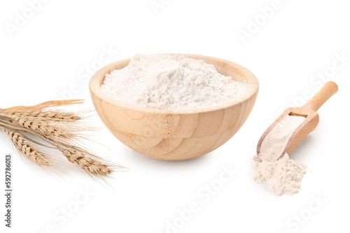 Wooden bowl with flour, scoop and wheat ears isolated on white background