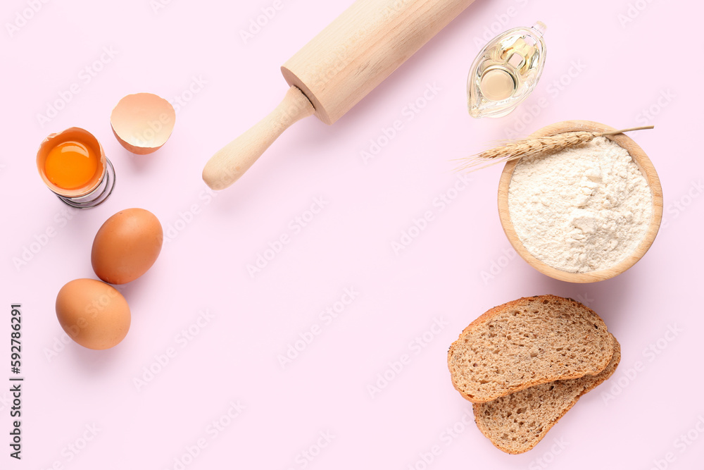Frame made of bowl with wheat flour, bread, eggs and rolling pin on pink background Frame made of bowl with wheat flour, bread, eggs and rolling pin on pink background