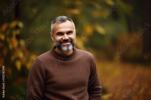 Portrait of a smiling middle-aged man in the autumn forest