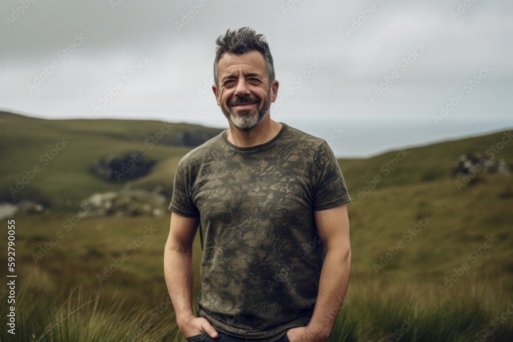 Portrait of a happy man standing on a mountain top in Scotland