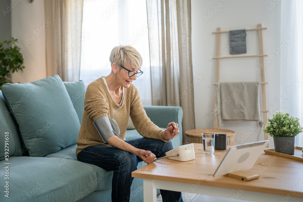 Senior caucasian woman check blood pressure measure device on hand Senior caucasian woman check blood pressure measure device on hand