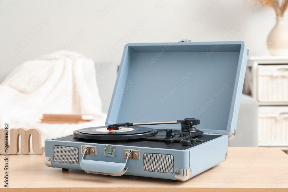 Fototapeta premium Record player with vinyl disk on table in room