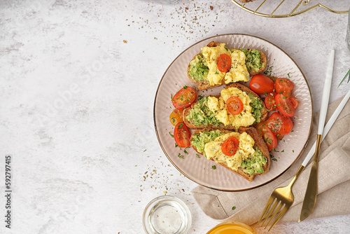 Foto Plate with tasty scrambled eggs sandwiches and vegetables on white background