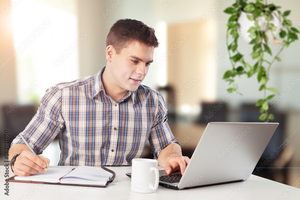 Cheerful male working on computer at home. Cheerful male working on computer at home.