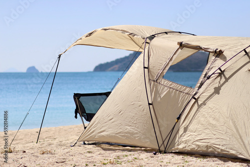 トイプードルを連れて女子キャンプ　青い海・美しいビーチでのんびり島キャンプ　キャンプ料理や愛犬と休日を楽しむ女性　海の見えるキャンプ © iju