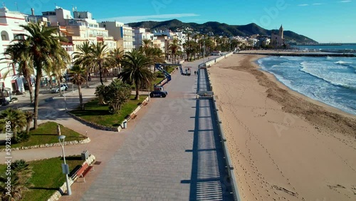 Wallpaper Mural Panoramic aerial drone view of coastal village, Sant Bartomeu i Santa Tecla de Sitges in Sitges. People are walking along embankment with classic white balustrade and empty terrace overlooking sea. 4K Torontodigital.ca