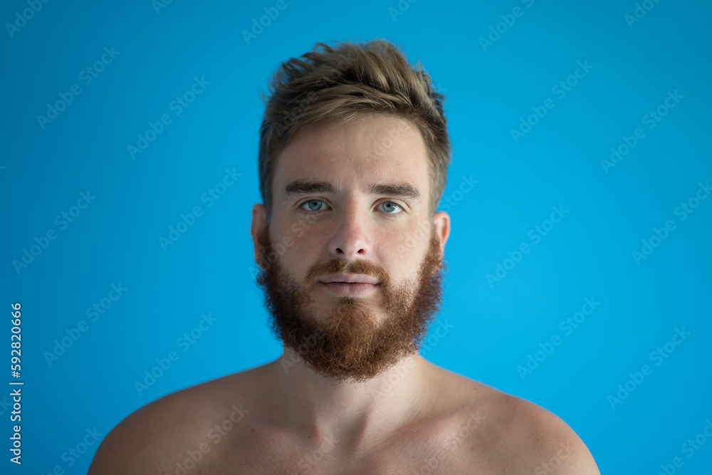 Obraz premium portrait of a young handsome man without clothes on a blue background