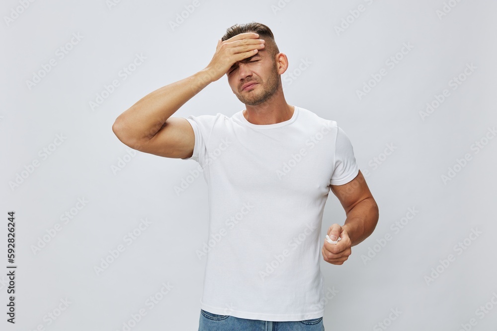 Man headache with pills in hand for pain and inflammation, high fever, white background, copy space Man headache with pills in hand for pain and inflammation, high fever, white background, copy space