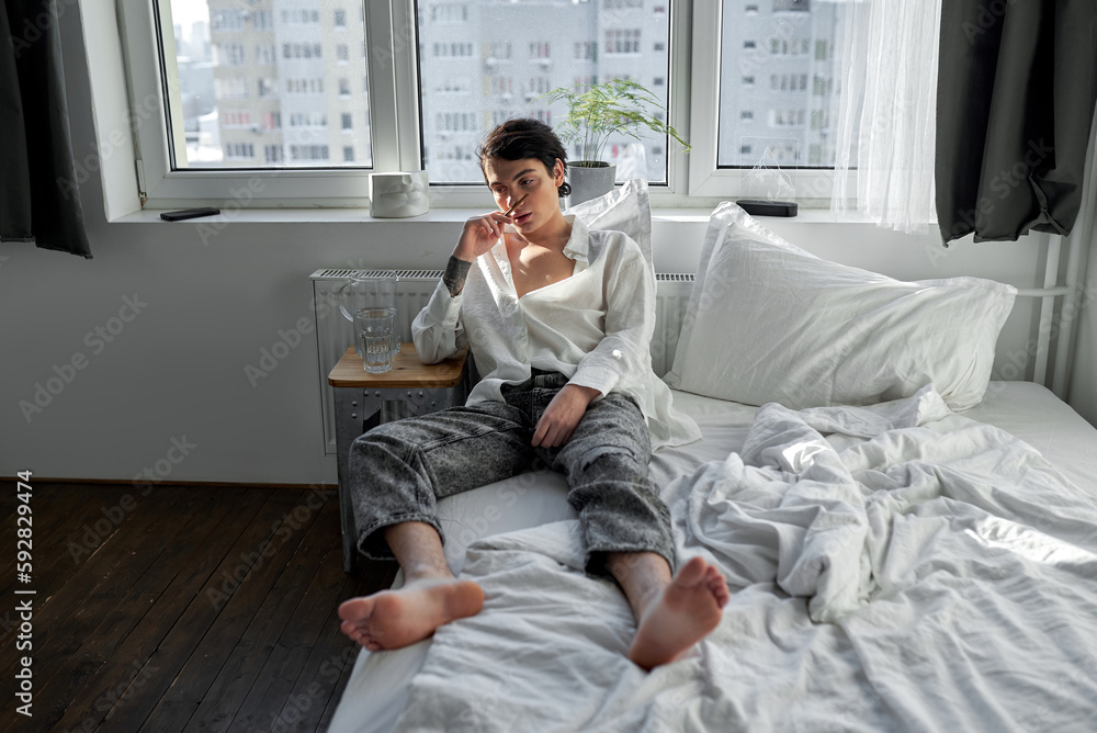 lonely young man thinks about future, guy holding cigarette, looking down.loneliness concept, full length shot lonely young man thinks about future, guy holding cigarette, looking down.loneliness concept, full length shot