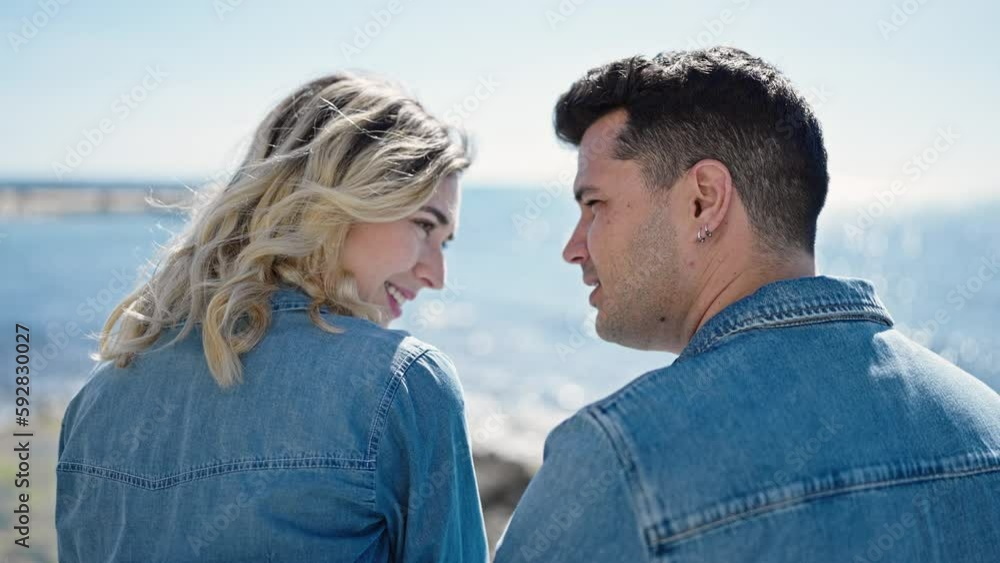 Man and woman couple smiling confident standing together kissing at seaside Man and woman couple smiling confident standing together kissing at seaside