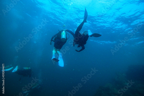 Wallpaper Mural Scuba Divers, silhouettes against sunburst, in the ocean beside coral reef Torontodigital.ca