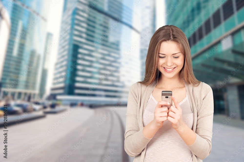 Fototapeta premium Young adult professional business woman holding smartphone