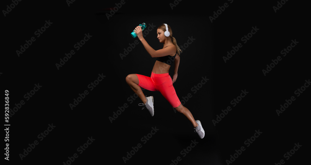 photo of woman sport runner with water bottle. woman sport runner isolated on black.