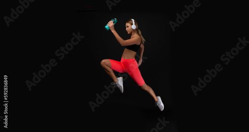 photo of woman sport runner with water bottle. woman sport runner isolated on black.