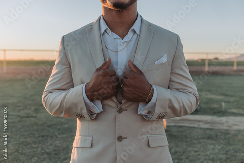 Groom clutching his suit jacket