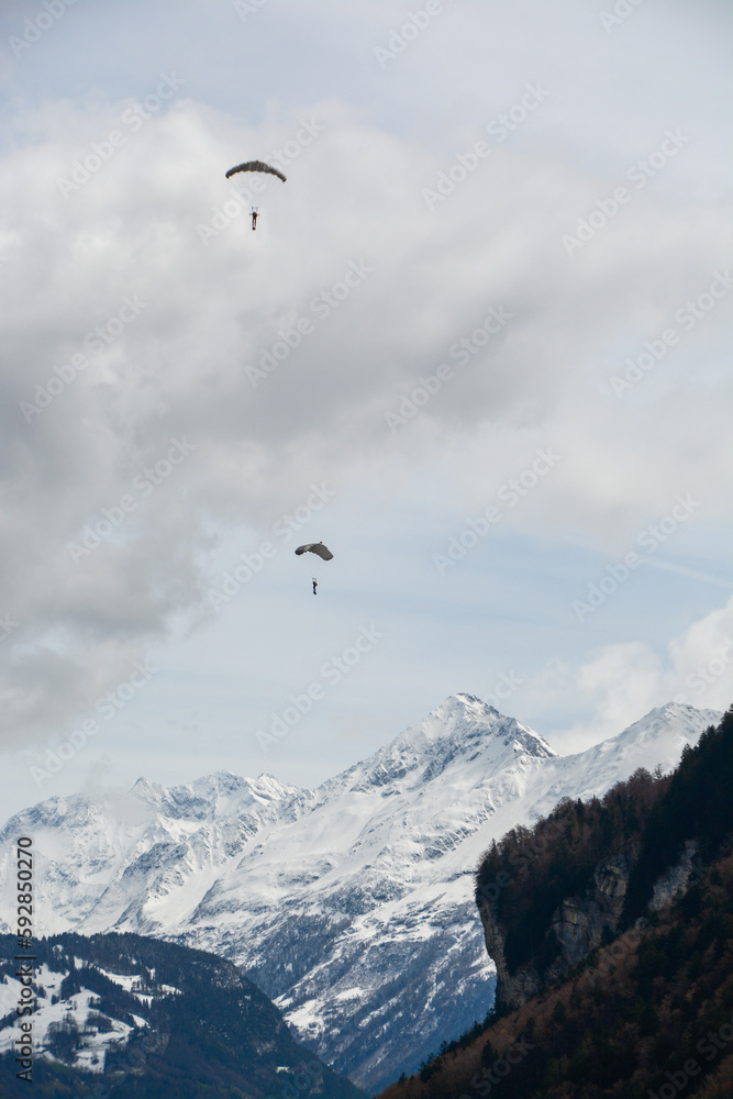 Swiss army paraglider over the mountains high up in the clouds
