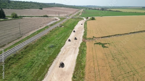 Aerial view of a UTV vehicles racing on a dirt road in nature