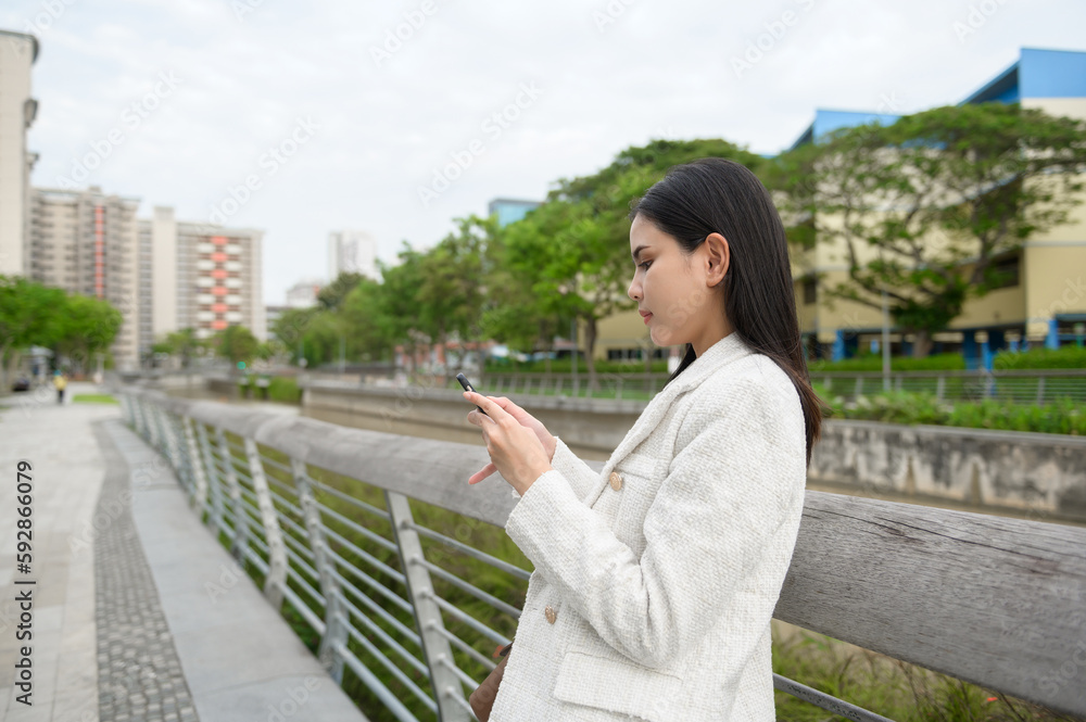 A young businesswoman is working in modern city downtown of Singapore A young businesswoman is working in modern city downtown of Singapore