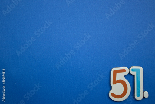 51. number of. Placed on the edge of the blue background, photographed from above.