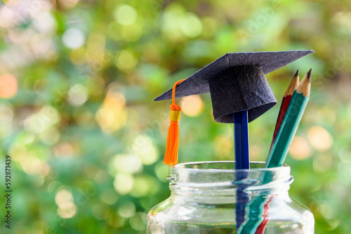 Photography Back to school or graduate certificate program concept : Black graduation cap and a pencil in a bottle