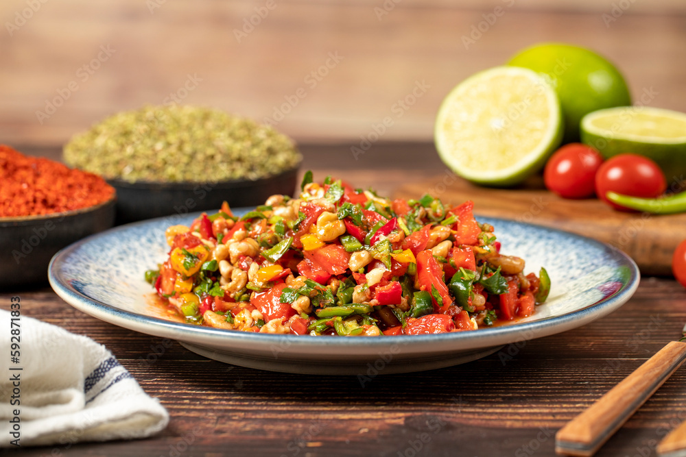 Gavurdagi salad. Walnut salad on wood background. Healthy salad prepared with tomatoes, peppers, cucumbers, onions, pomegranate syrup, olive oil and walnuts Gavurdagi salad. Walnut salad on wood background. Healthy salad prepared with tomatoes, peppers, cucumbers, onions, pomegranate syrup, olive oil and walnuts