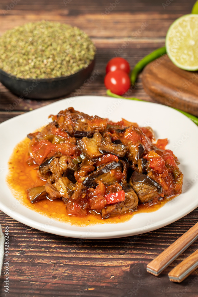 Eggplant dish with vegetables fried in olive oil on a wooden floor. Close up Eggplant dish with vegetables fried in olive oil on a wooden floor. Close up