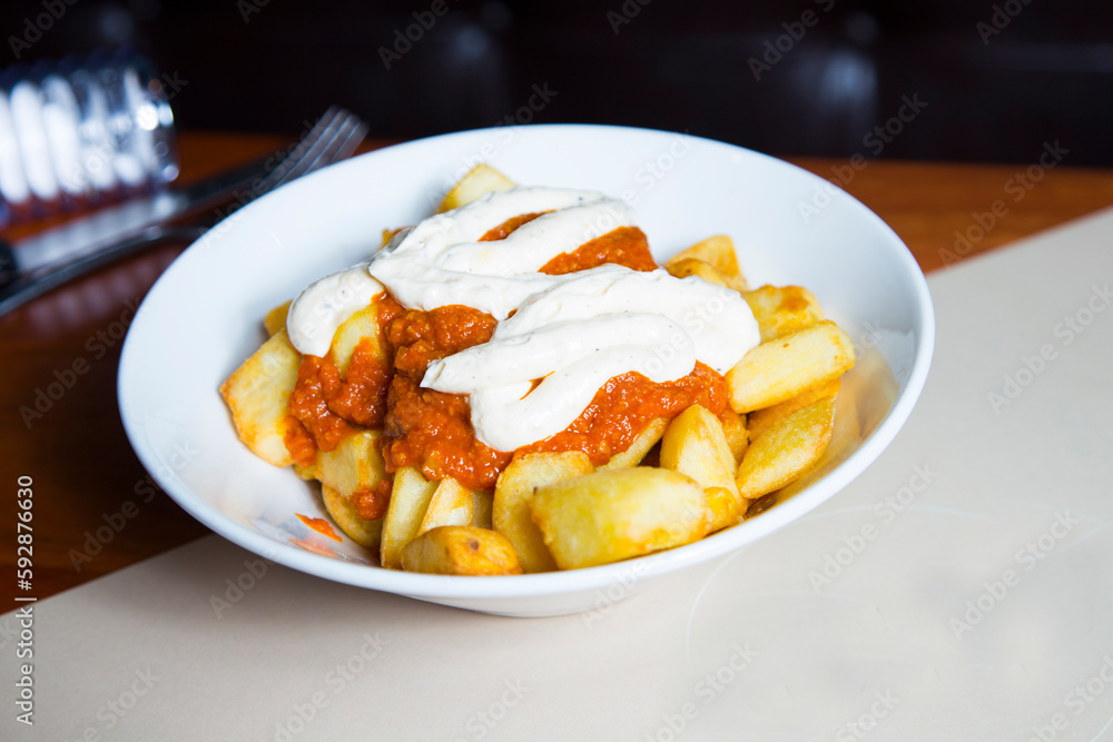 Papas bravas, are a typical preparation of bars in Spain consisting of potatoes cut into large cubes, fried in olive oil and seasoned with salsa brava, which is a spicy sauce. Papas bravas, are a typical preparation of bars in Spain consisting of potatoes cut into large cubes, fried in olive oil and seasoned with salsa brava, which is a spicy sauce.