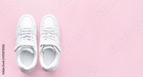 White sneakers on a pink background.