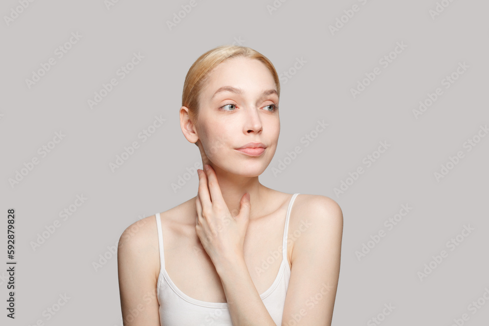 Gorgeous woman touching her neck isolated on grey background. Beauty, cosmetics, skincare, glamour Gorgeous woman touching her neck isolated on grey background. Beauty, cosmetics, skincare, glamour