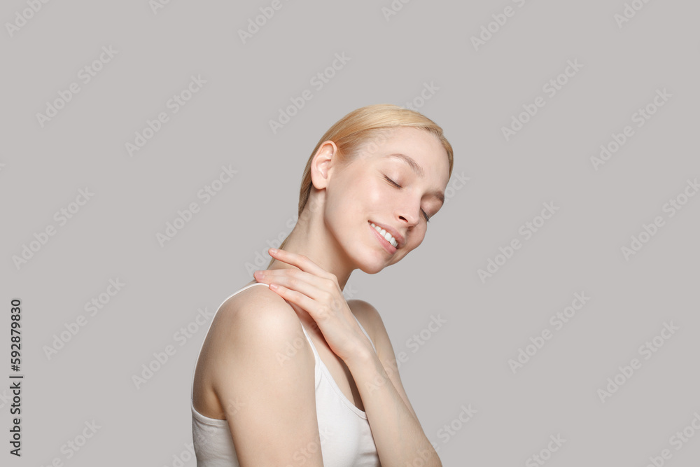 Cute woman with blonde ponytail smiling isolated on grey background. Beauty,cosmetics, skincare, glamour. Cute woman with blonde ponytail smiling isolated on grey background. Beauty,cosmetics, skincare, glamour.