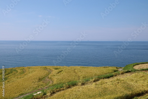 野津半島の風景、輪島・白米千枚田。海辺に広がる稲刈りの時期を迎えた棚田。 © onaka