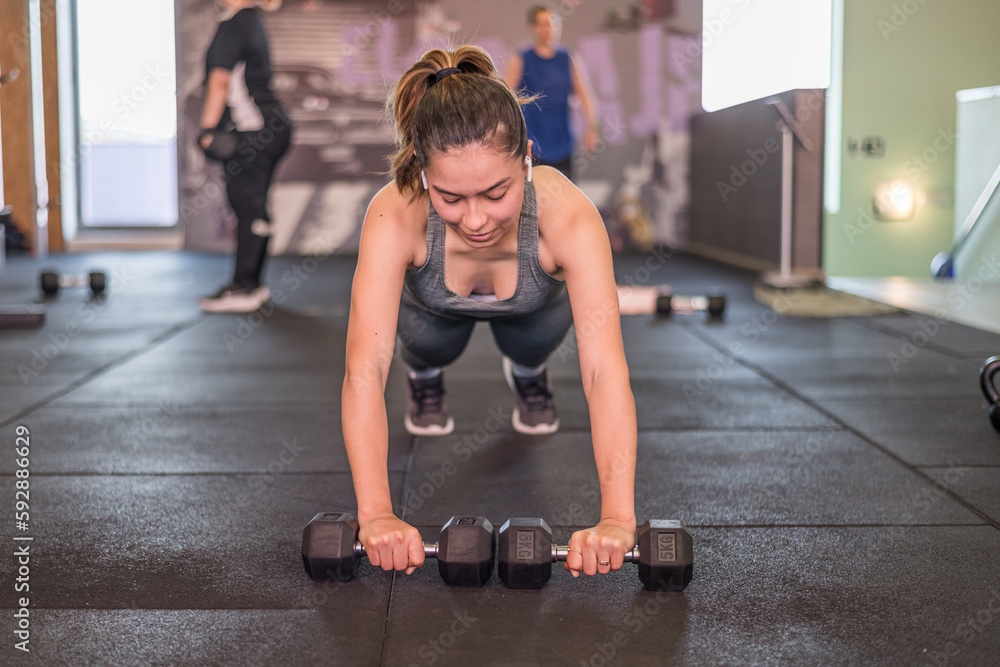 Young Latin Woman Training Hard In The Health Club. In the gym