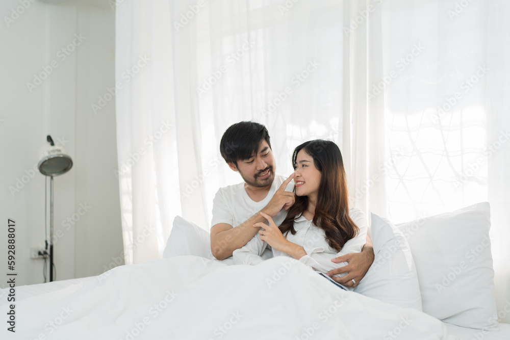 Asian Romantic couple in bed enjoying sensual foreplay Happy sensual young couple lying in bed together. Beautiful loving couple kissing in bed. Asian Romantic couple in bed enjoying sensual foreplay Happy sensual young couple lying in bed together. Beautiful loving couple kissing in bed.